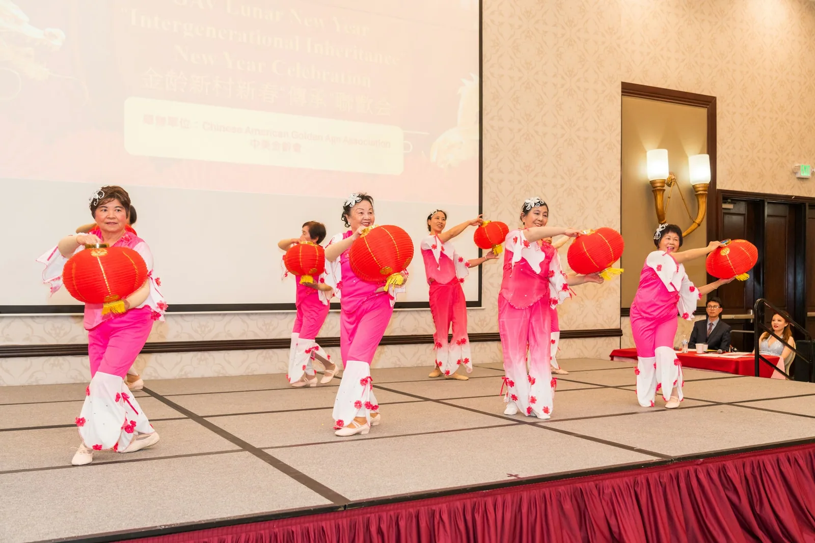 新年慶祝活動上，長者身穿粉色舞衣、手持紅燈籠在台上表演舞蹈
