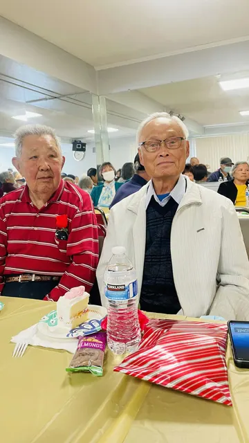 兩位住戶在生日會餐桌前合影