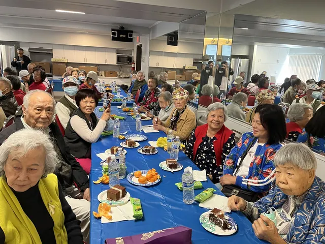 住戶在生日會餐桌旁微笑合影