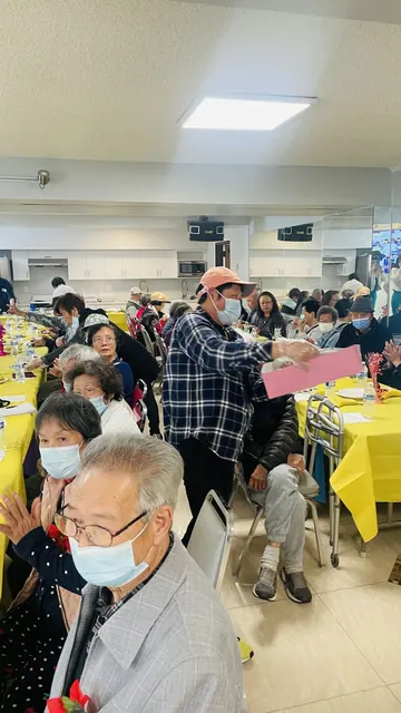 生日會現場，工作人員在餐桌間向住戶分發資料