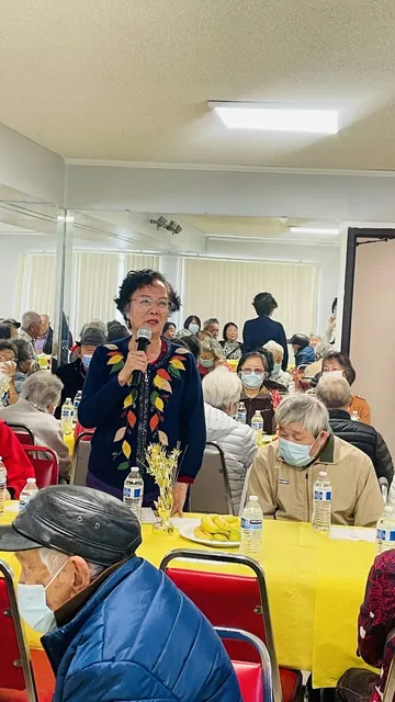 一位住戶在生日會上手持麥克風發言
