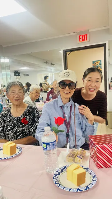 住戶在生日會上合影，桌上擺著蛋糕