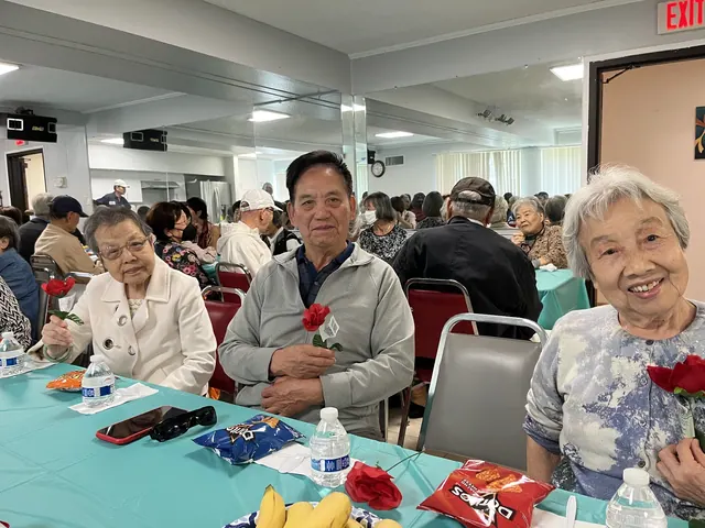 住戶手持紅玫瑰在生日會上合影