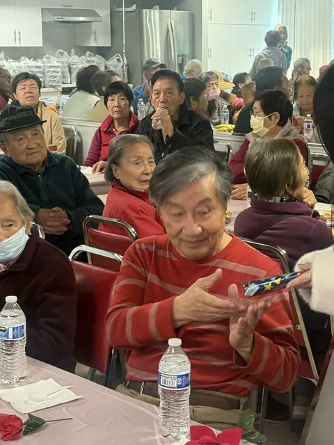 A resident receiving a wrapped birthday gift from a staff member