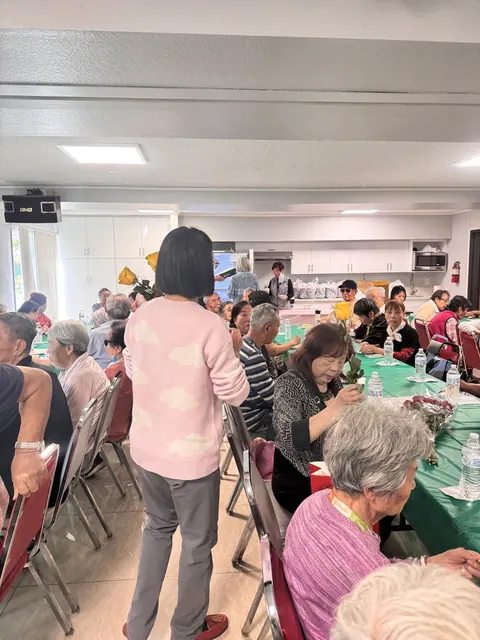 工作人員穿梭桌間與住戶交流,住戶手持鮮花