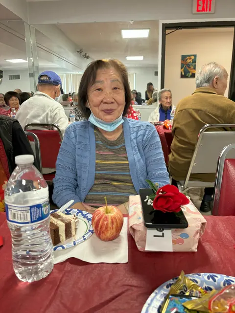 長者在餐桌旁與生日蛋糕及禮物合影