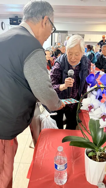 壽星在生日會上持麥克風發言並接受禮物