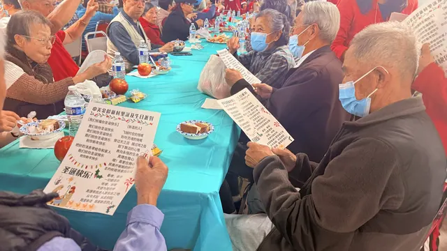 住戶圍坐餐桌，看著歌詞單一起唱歌