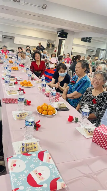 住戶圍坐長桌，桌上擺著橘子與點心