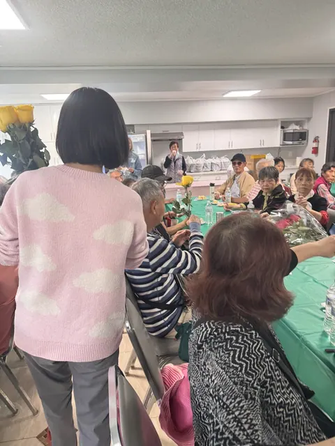 住戶手持玫瑰聆聽分享,工作人員在旁陪伴