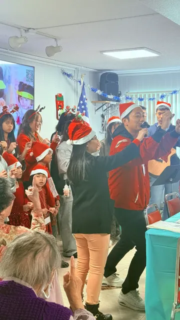 錦光教會成員戴著聖誕帽在生日會上演唱表演