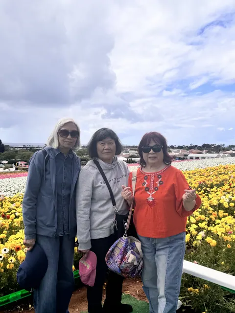 三位住戶在黃白花海前合影