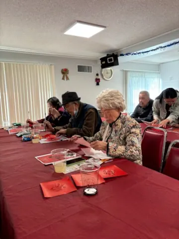 住戶圍坐長桌參與新年寫福字活動